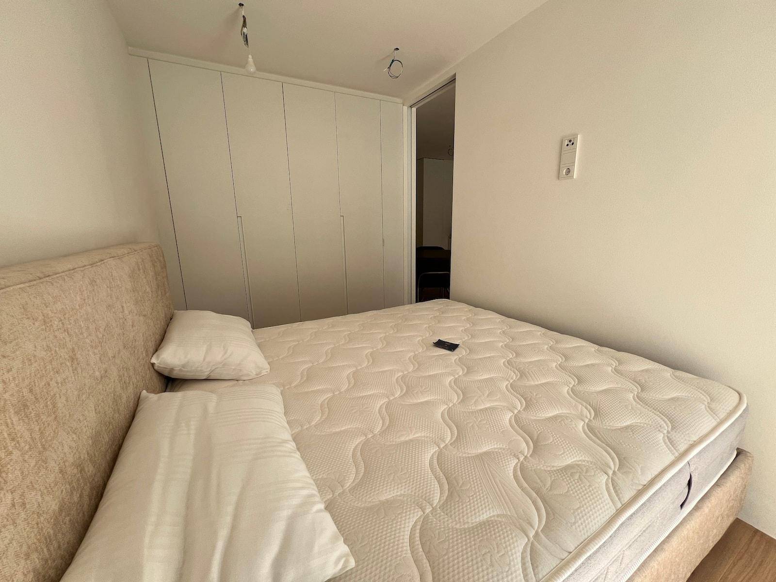 Schlafzimmer mit Doppelbett und integrierten weißen Einbauschränken für viel Stauraum.