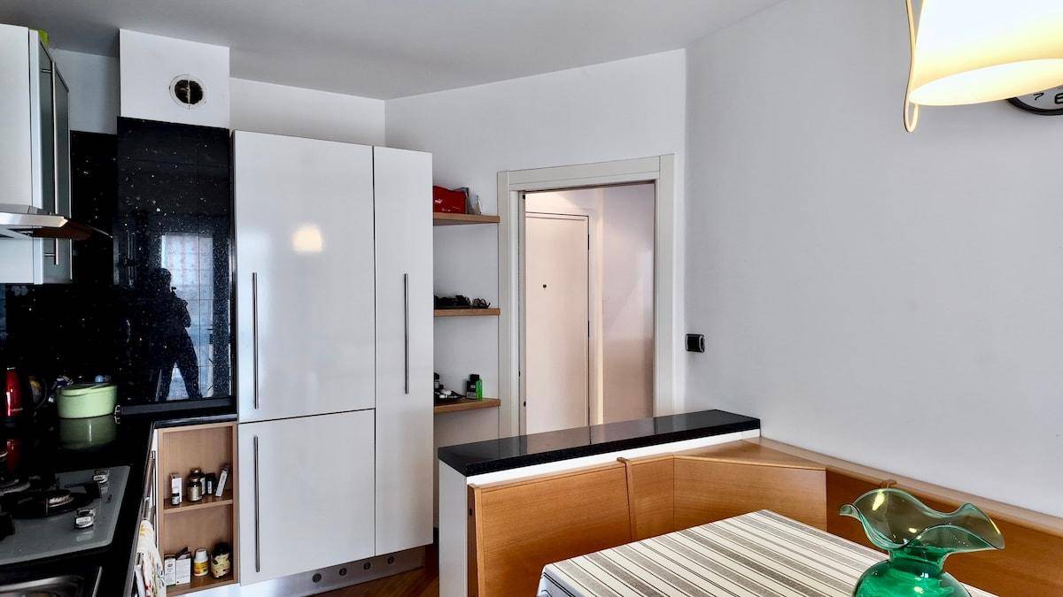 Küchenbereich mit integriertem Kühlschrank und Übergang zum Flur.