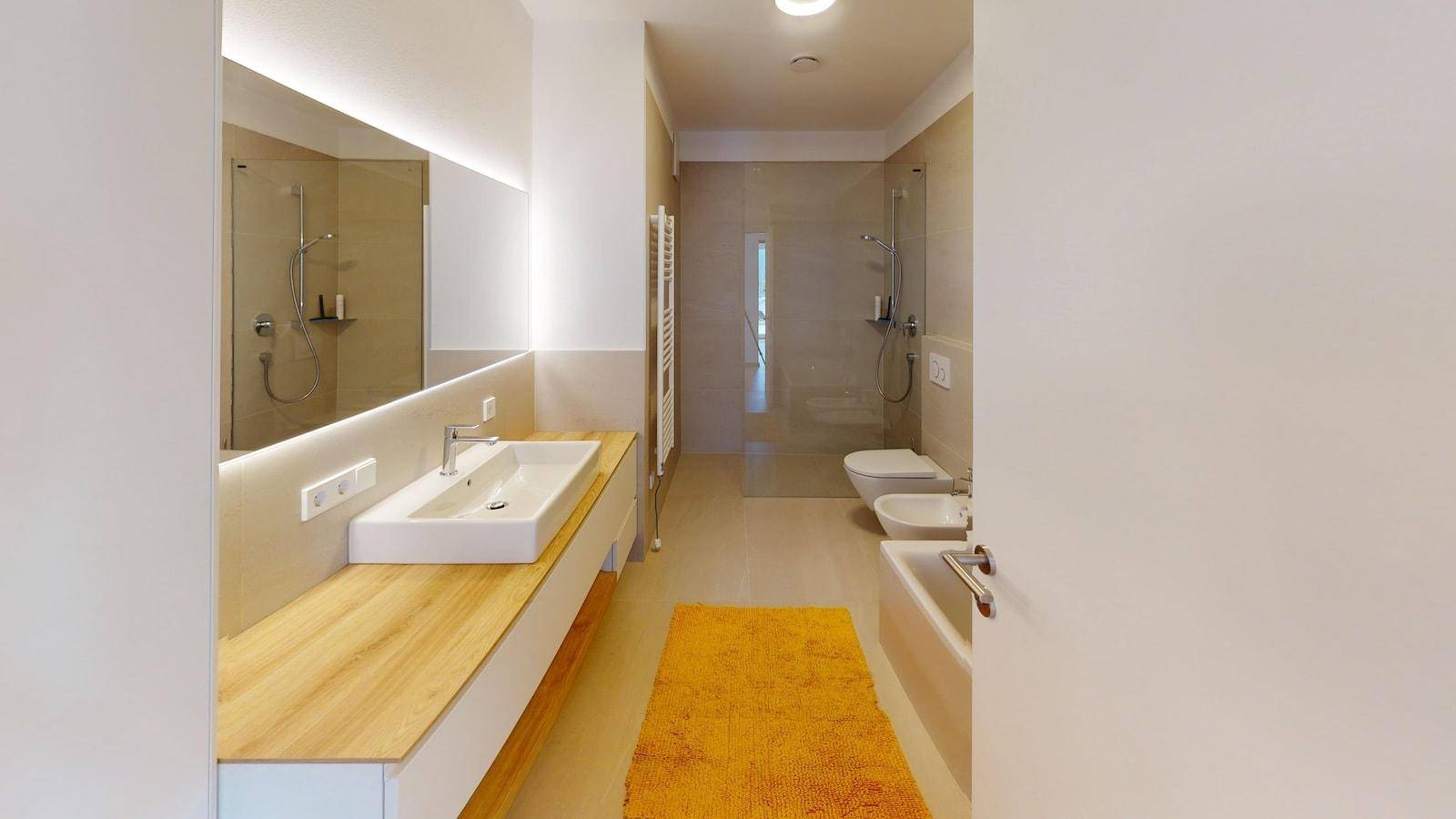 Geräumiges, modernes Badezimmer mit Waschtisch, Dusche, Badewanne, WC und Bidet.