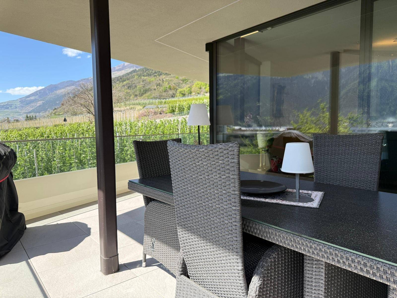 Terrasse mit modernen Outdoor-Möbeln und einem schönen Ausblick auf die Natur.