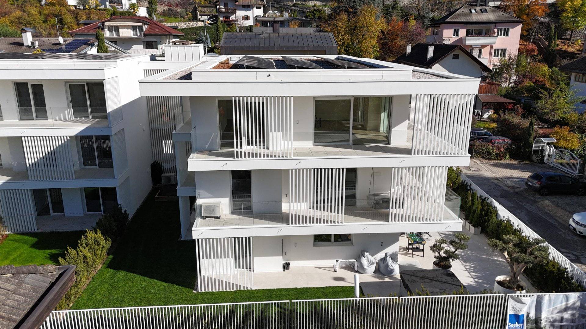Moderne Wohnanlage mit gepflegtem Garten und Außensitzbereich.