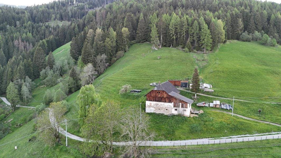 Luftaufnahme eines ländlichen Anwesens mit traditionellen Gebäuden, umgeben von grünen Terrassenfeldern.