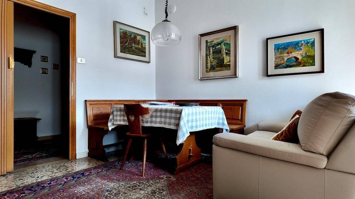 Essbereich mit traditioneller Holzbank und Tisch in einem gemütlichen Wohnraum.