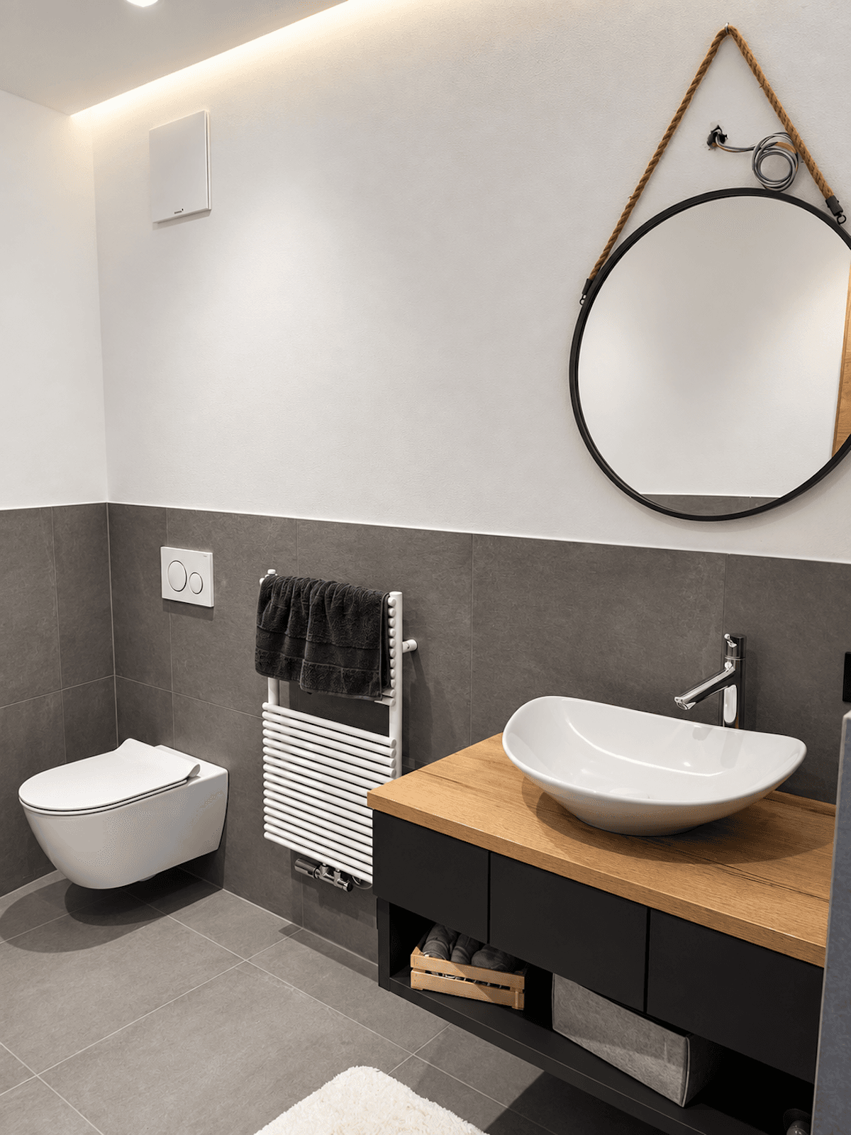 Modernes Gäste-WC mit stilvollem Waschbecken, Wand-WC und beheiztem Handtuchhalter.