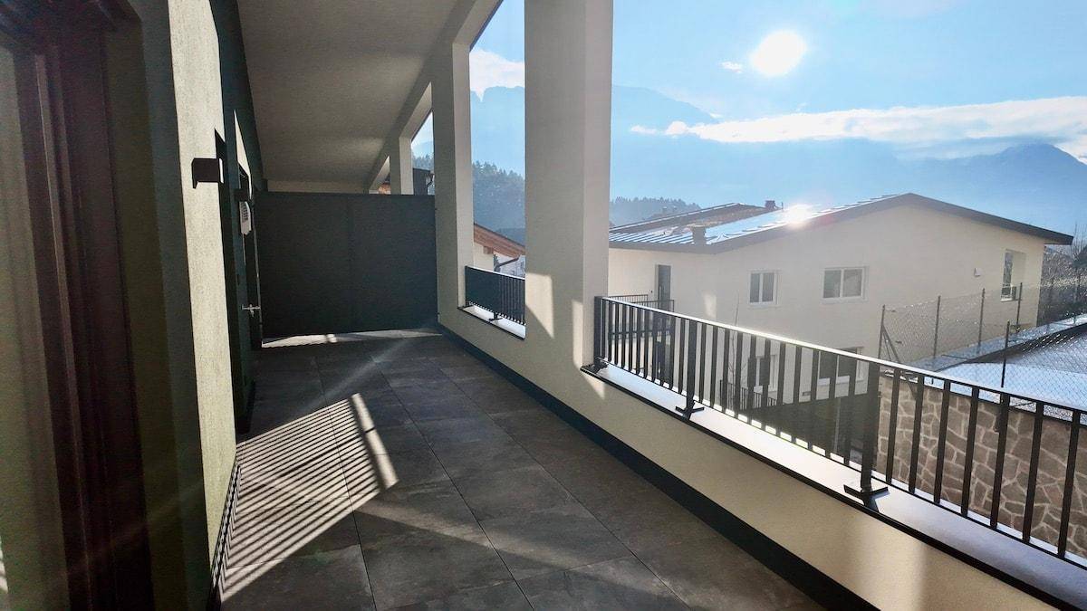 Geräumige Terrasse mit Fliesenboden und Bergblick, ideal für sonnige Tage.
