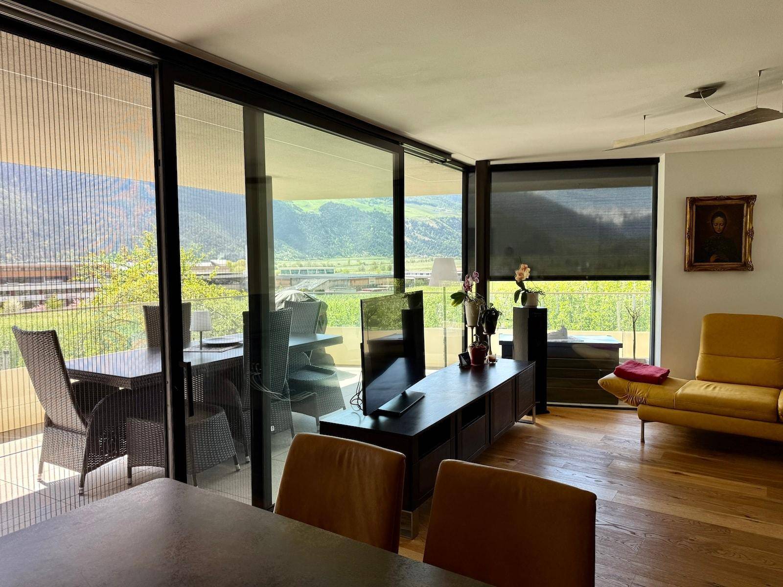 Heller Wohn- und Essbereich mit großen Fenstern, die einen weiten Blick auf die Landschaft bieten.