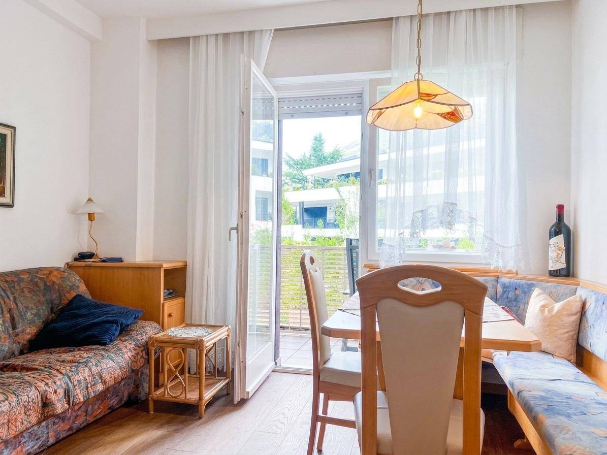 Gemütlicher Wohn-Essbereich mit Sofa, Esstisch und direktem Zugang zum Balkon.
