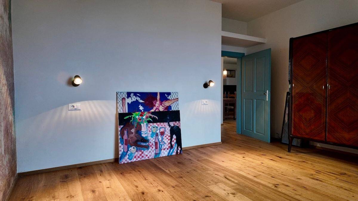 Raum mit hellem Holzboden, pastellblauer Wand und moderner Dekoration.