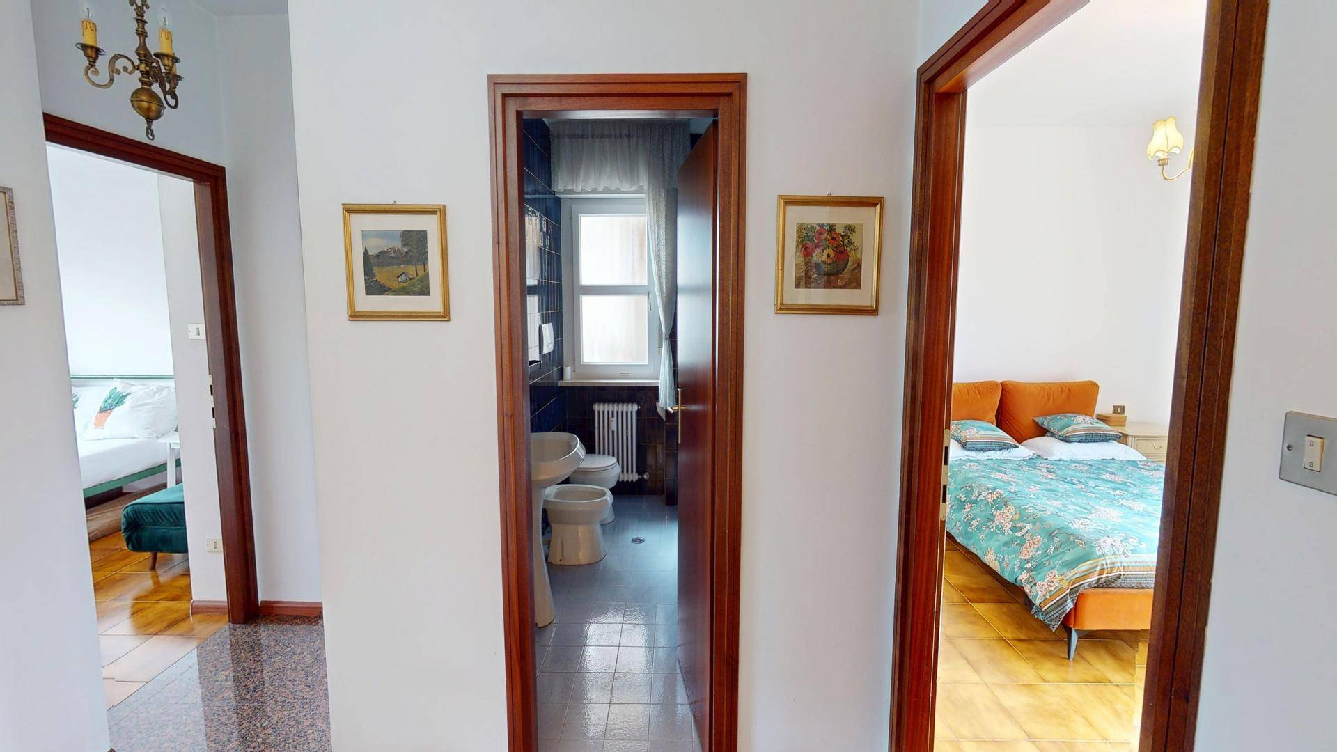Flur mit Terrazzoboden und Zugang zu Schlafzimmern und Badezimmer.