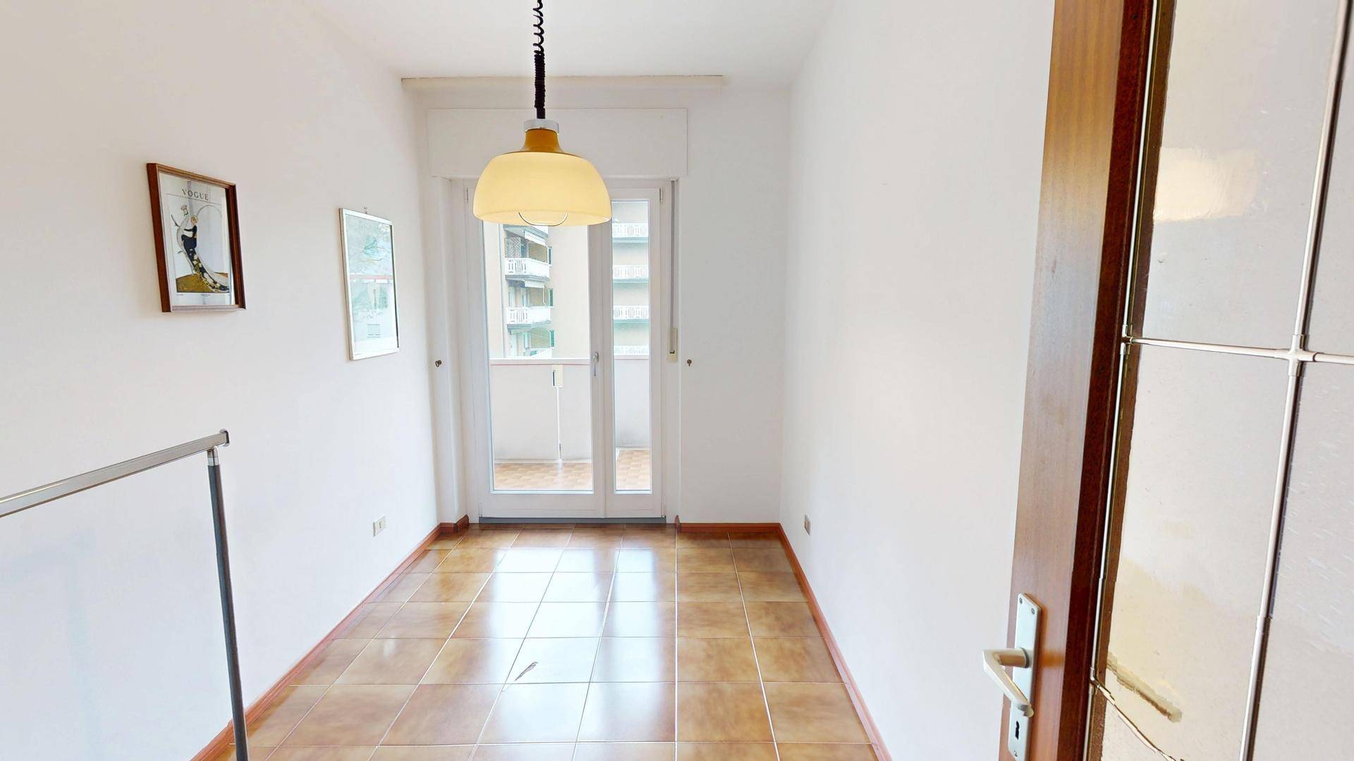 Leerer Raum mit Fliesenboden und Zugang zu einem Balkon, ideal für individuelle Gestaltung.