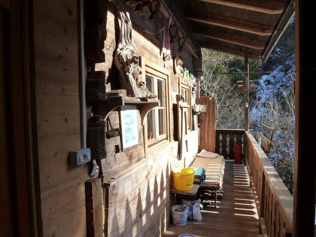 Gemütliche Holzloggia mit Blick auf die verschneite Waldlandschaft, ideal zum Entspannen im Freien.