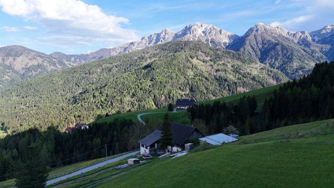 Anwesen in idyllischer Lage mit weitem Blick über grüne Hügel und die schneebedeckten Alpen.