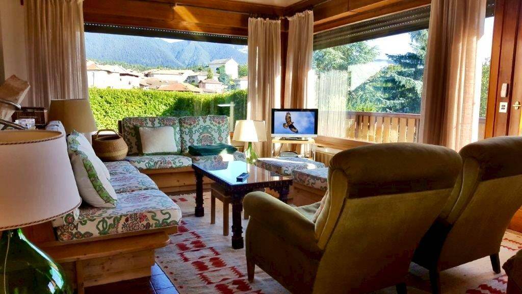 Helles Wohnzimmer mit großen Fenstern, gemütlichen Sofas und Blick ins Grüne.