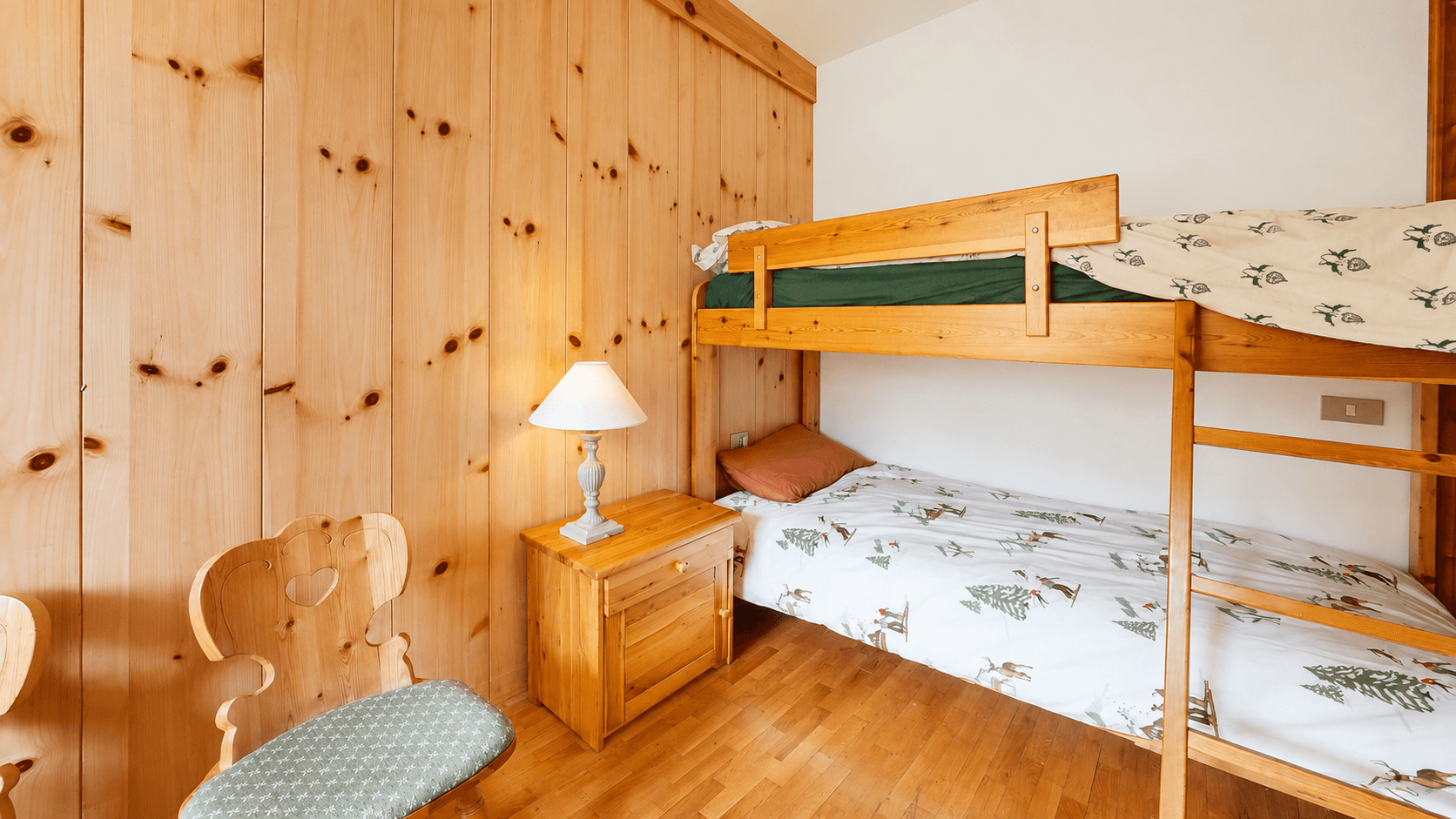 Detailansicht des Etagenbetts im Schlafzimmer mit Nachttisch und Lampe.