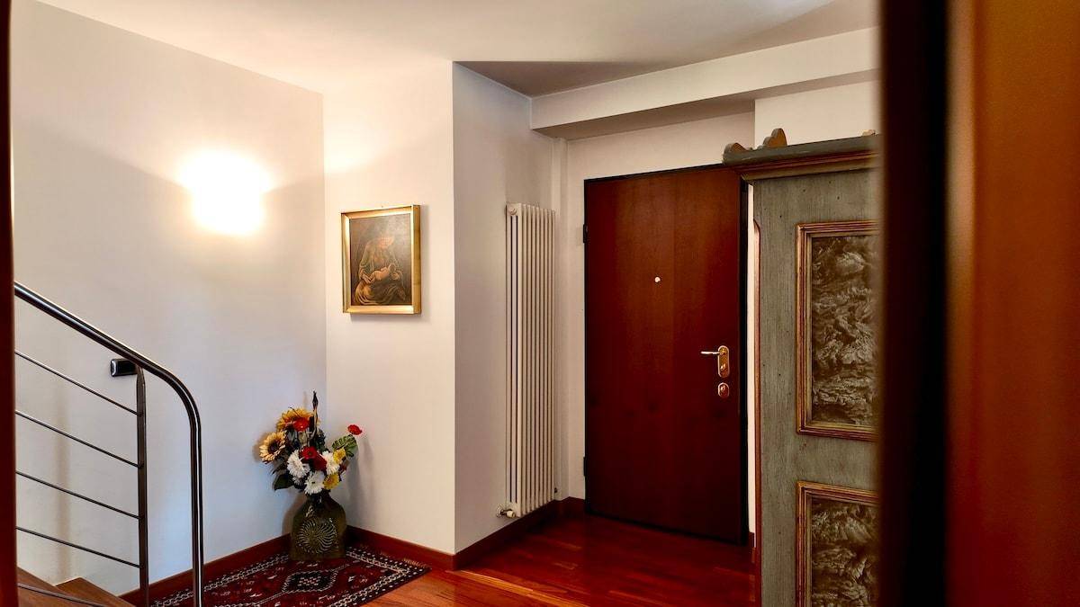 Eingangsbereich mit Holzboden, Treppe und dekorativen Elementen.