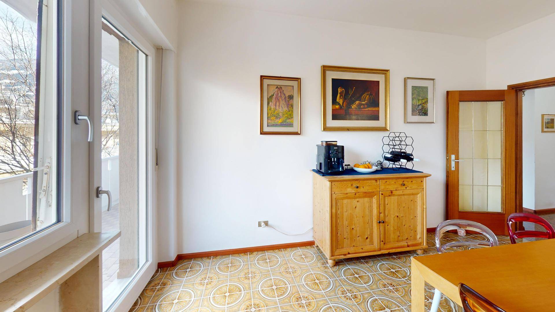 Helles Esszimmer mit Balkonzugang und Blick nach draußen.