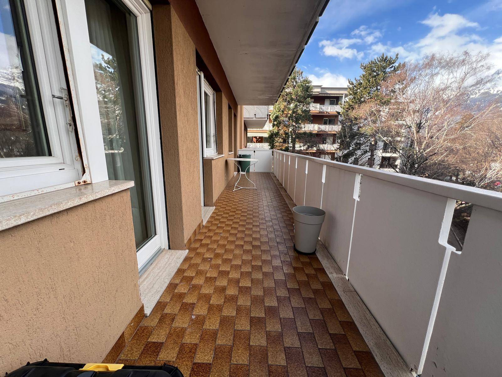 Balkon mit kleinem Tisch und Stühlen, ideal für Mahlzeiten im Freien.