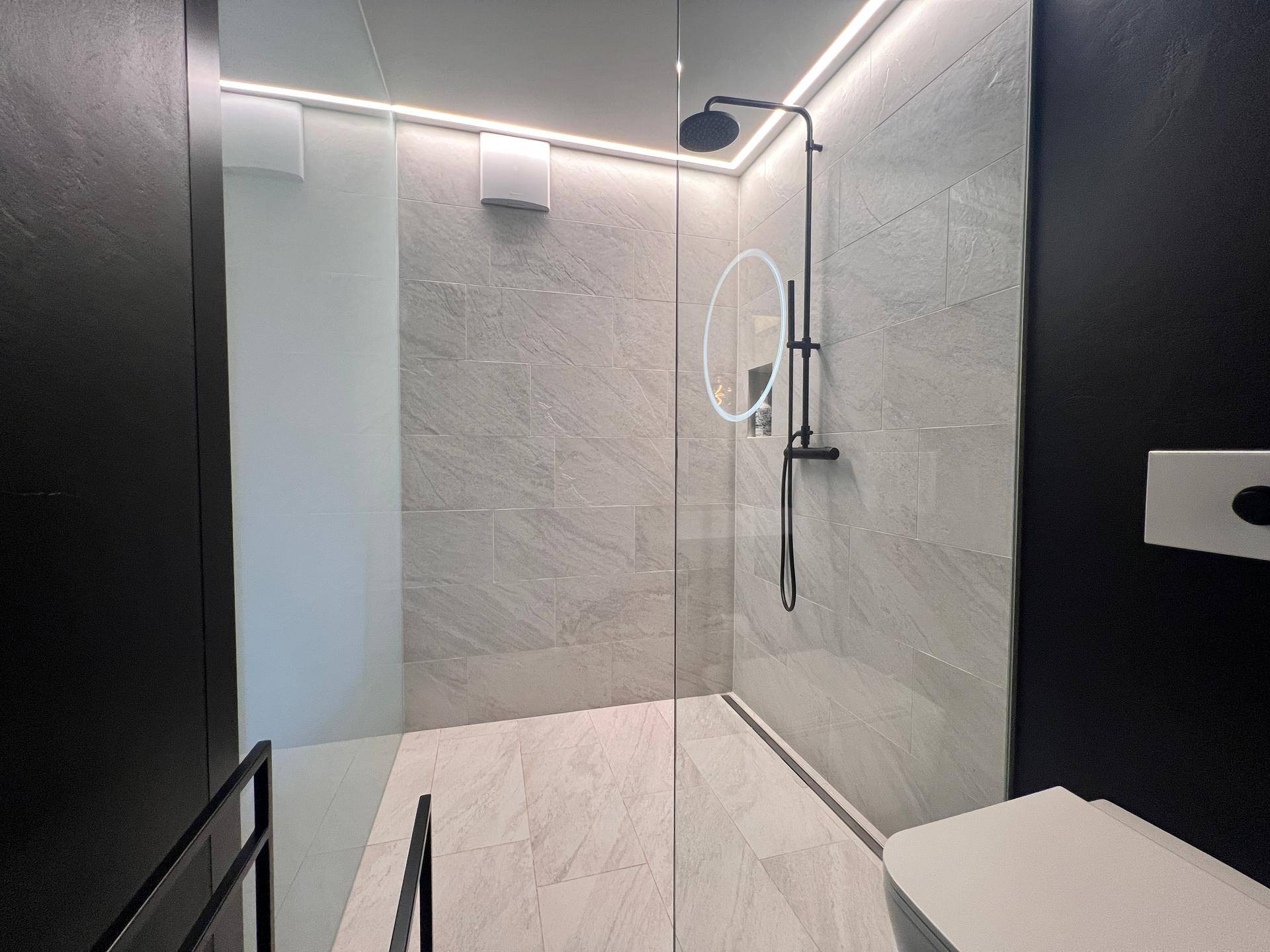 Geräumige begehbare Dusche mit modernen Fliesen und minimalistischem Design.