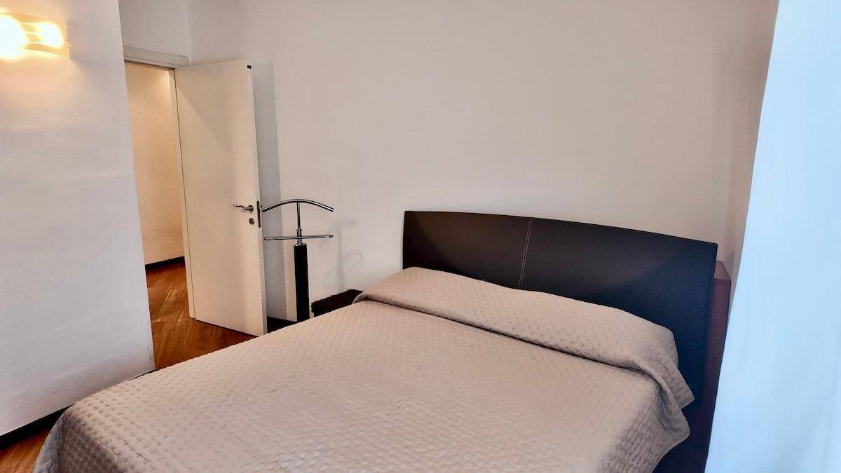 Schlafzimmer mit Doppelbett und Holzboden, bereit zur individuellen Gestaltung.