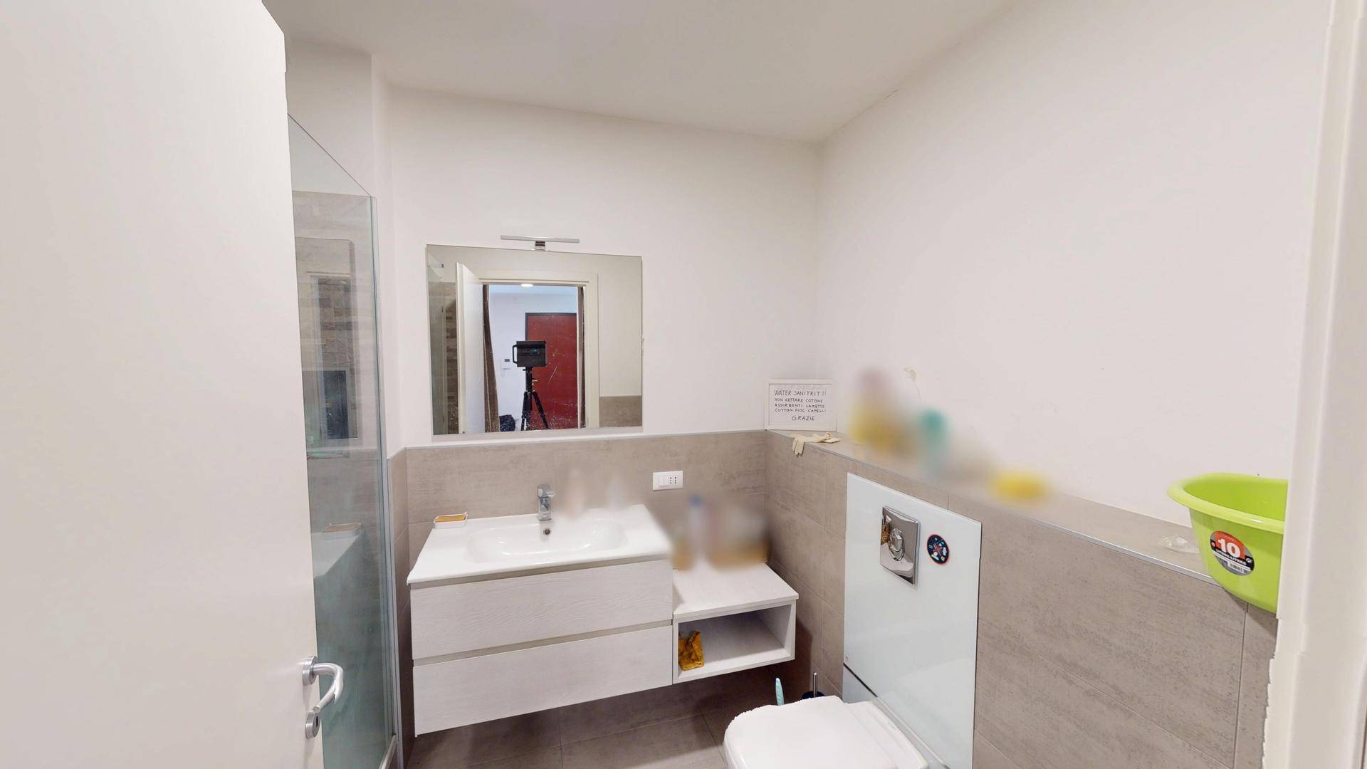 Modernes Badezimmer mit Waschtisch, Spiegel und Duschkabine.