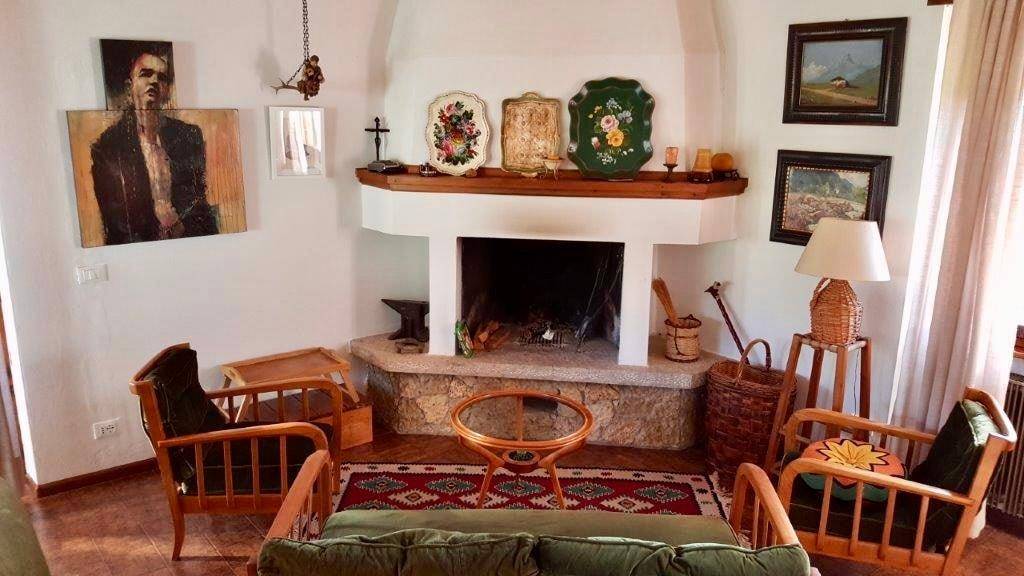 Gemütliches Wohnzimmer mit Kamin, rustikalen Möbeln und traditioneller Dekoration.