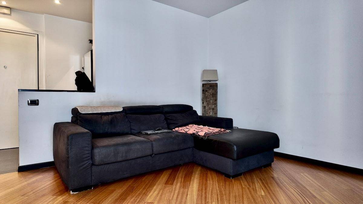 Wohnzimmer mit großem Ecksofa und Holzboden, ideal zum Entspannen.
