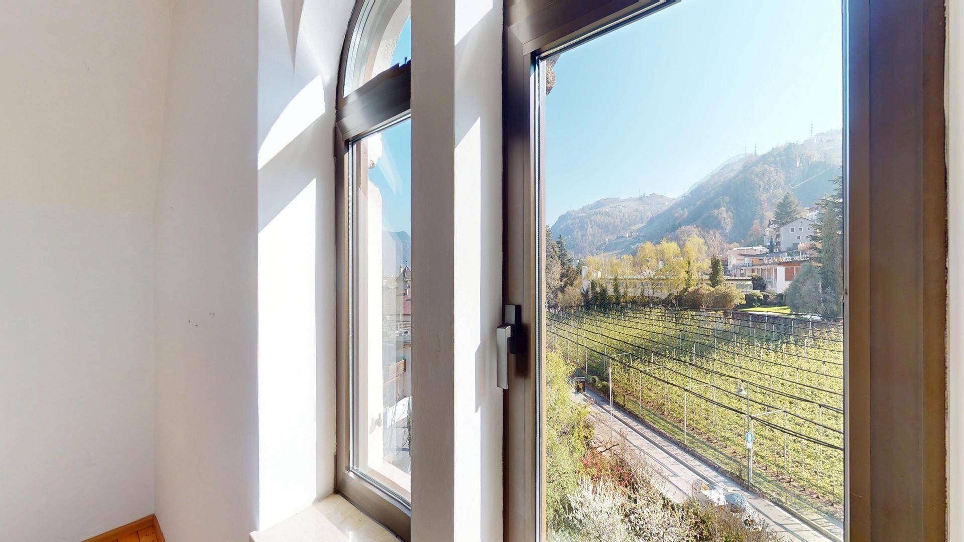 Panoramablick aus dem Fenster auf Weinberge und die umliegende Berglandschaft.