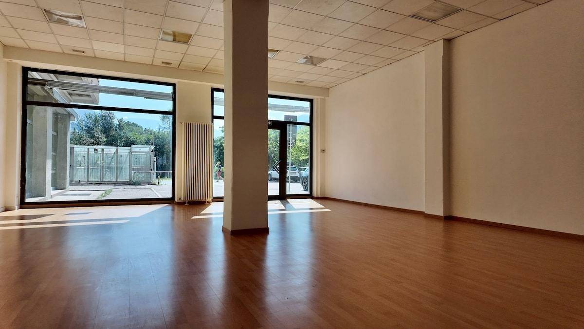 Heller, offener Büroraum mit Holzboden und viel Tageslicht durch die großen Fensterfronten.