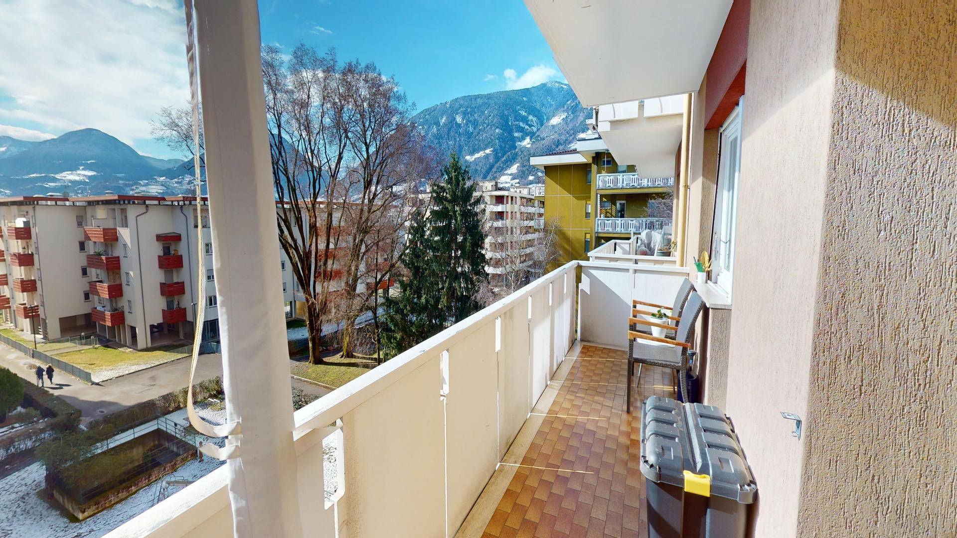 Geräumiger Balkon mit Fliesenboden und weitem Blick auf die umliegende Berglandschaft.