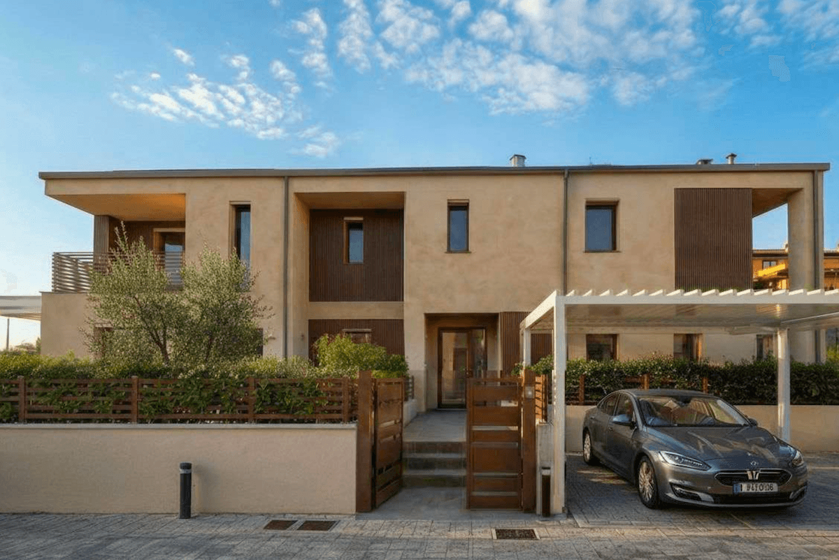 Moderne Reihenhausfassade mit Eingangsbereich, Carport und gepflegtem Vorgarten.