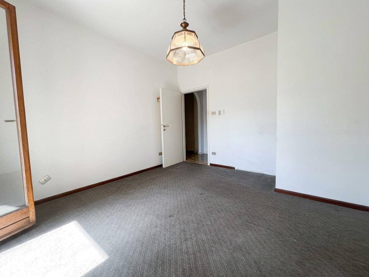 Leerer Raum mit Teppichboden und einfacher Deckenleuchte, bereit zur individuellen Gestaltung.