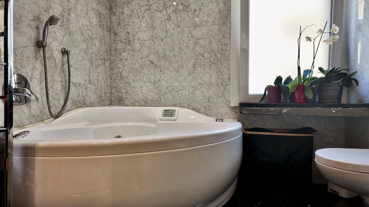 Detailansicht der Whirlpool-Badewanne im eleganten Marmorbad.