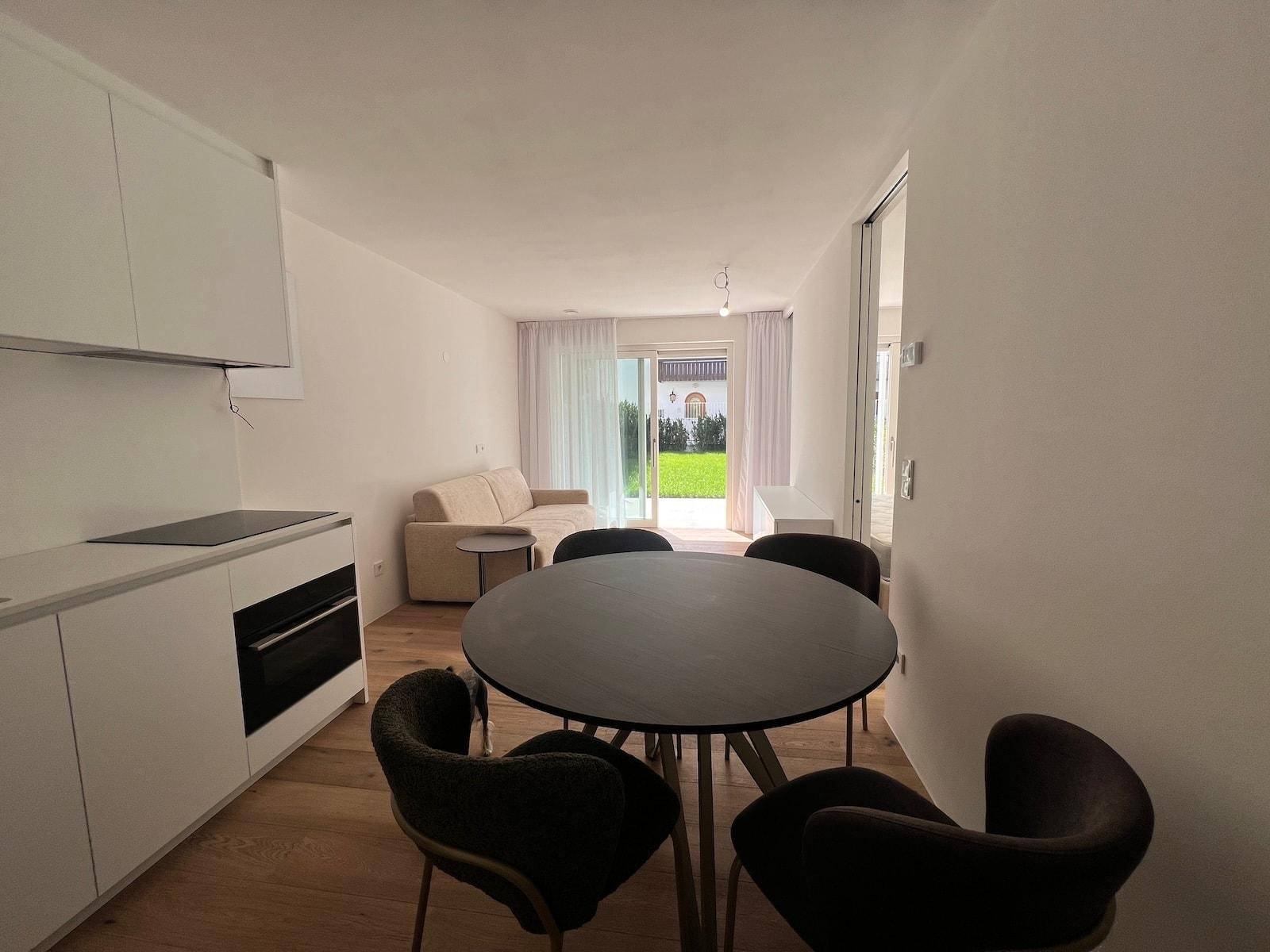Helle Wohnküche mit Essbereich und offenem Übergang zum Wohnzimmer mit Gartenzugang.