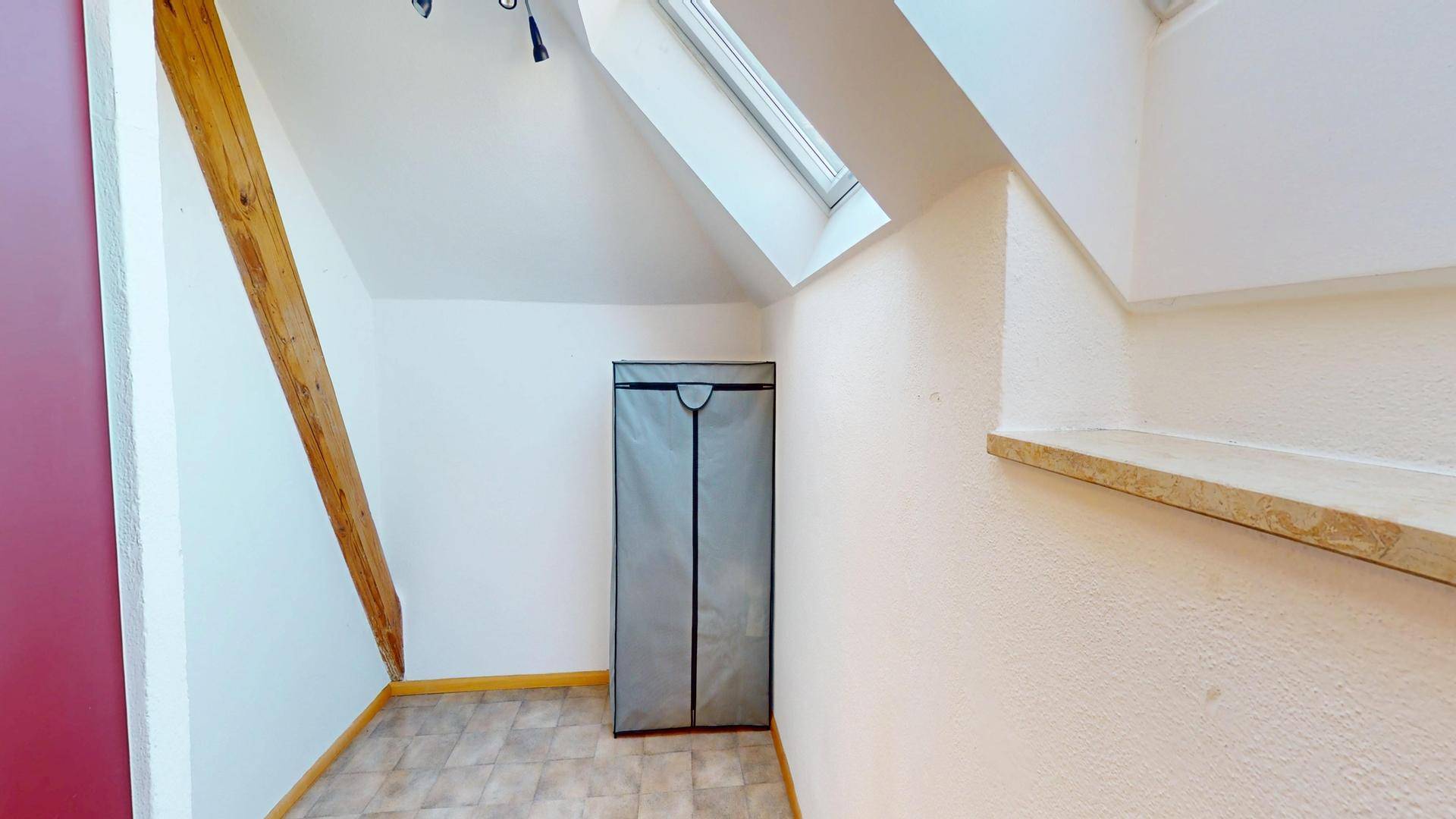Abstellbereich in der Küche mit Dachschräge, Holzbalken und Oberlicht.