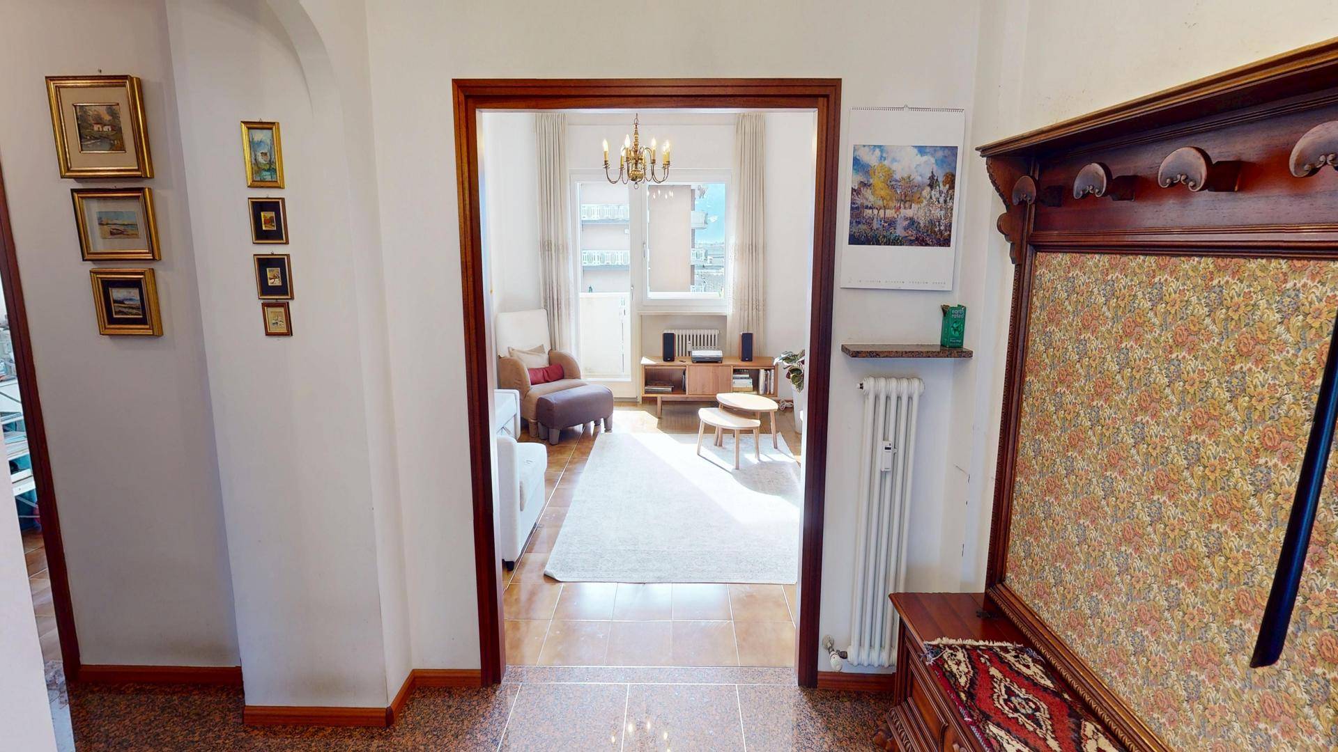 Heller Flur mit Terrazzoboden und offenem Zugang zum Wohnzimmer.