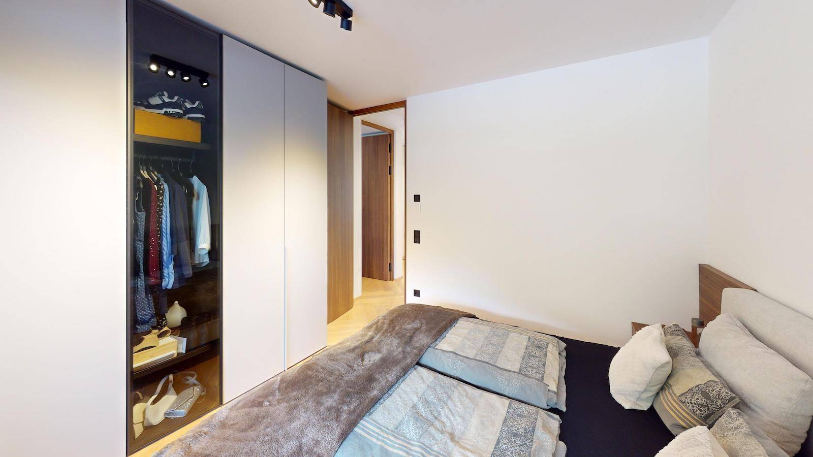 Schlafzimmer mit Doppelbett und integriertem Kleiderschrank.