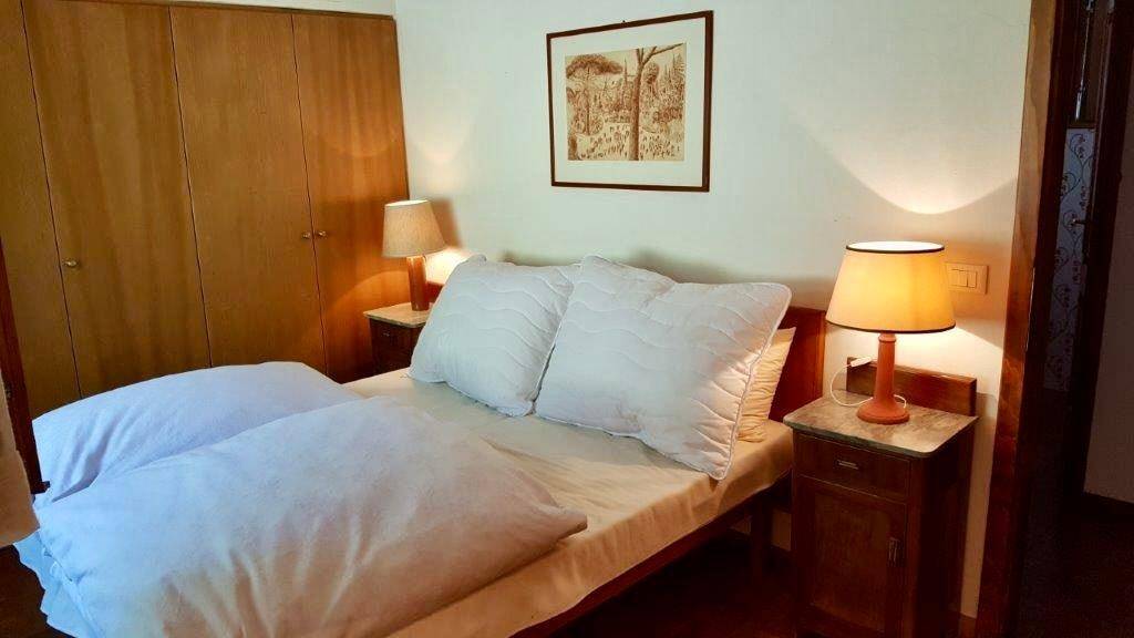 Schlafzimmer mit Doppelbett, Nachttischen und Einbauschränken aus Holz.