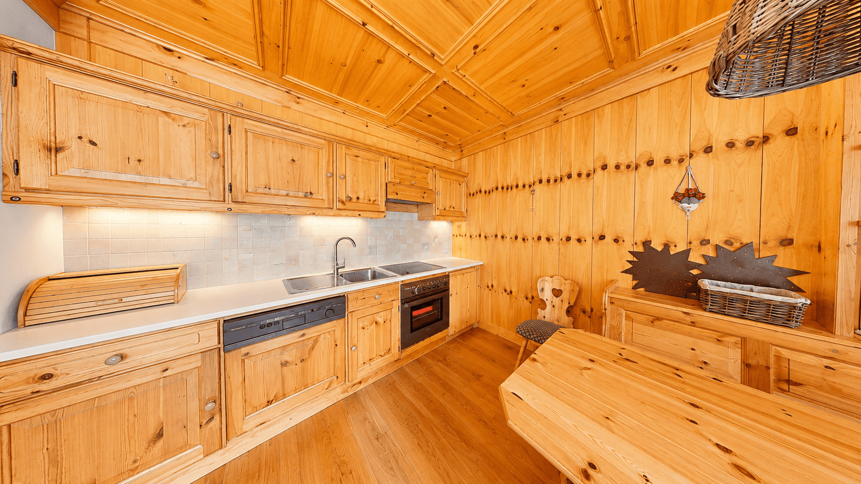 Gemütliche Holzküche mit Essbereich, Einbaugeräten und rustikalem Ambiente.