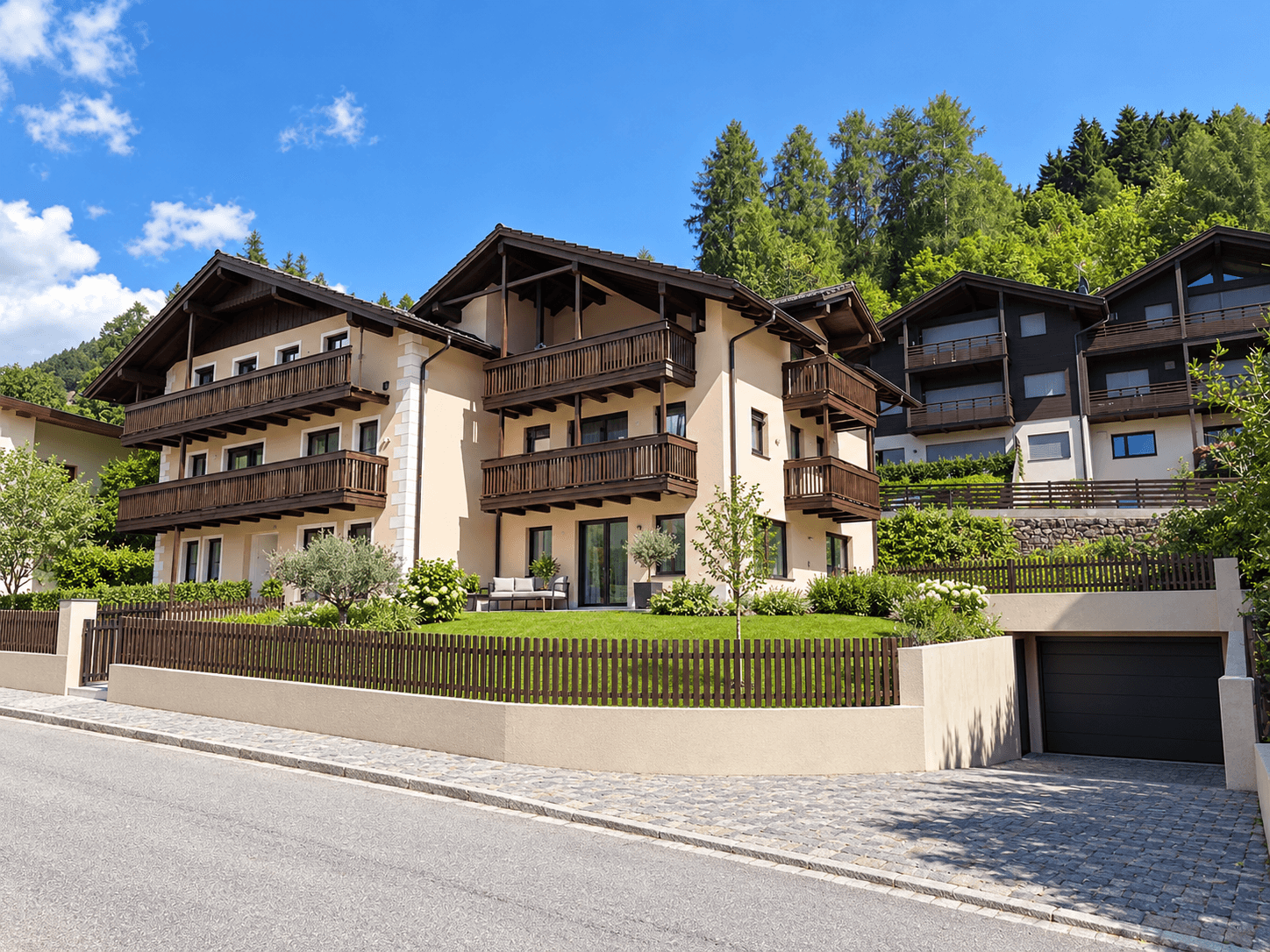 Fertiggestellter Neubau im alpinen Stil mit gepflegtem Garten, Balkonen und Bergblick.