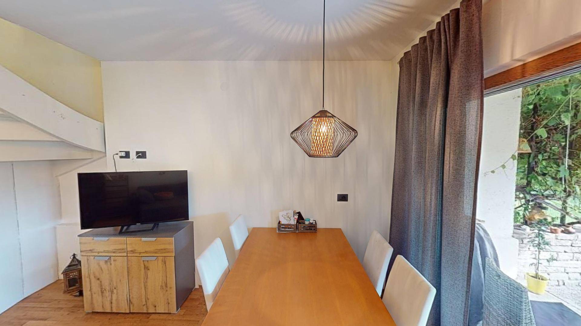Heller Essbereich mit Holztisch, modernen Stühlen und direktem Zugang zur Terrasse.