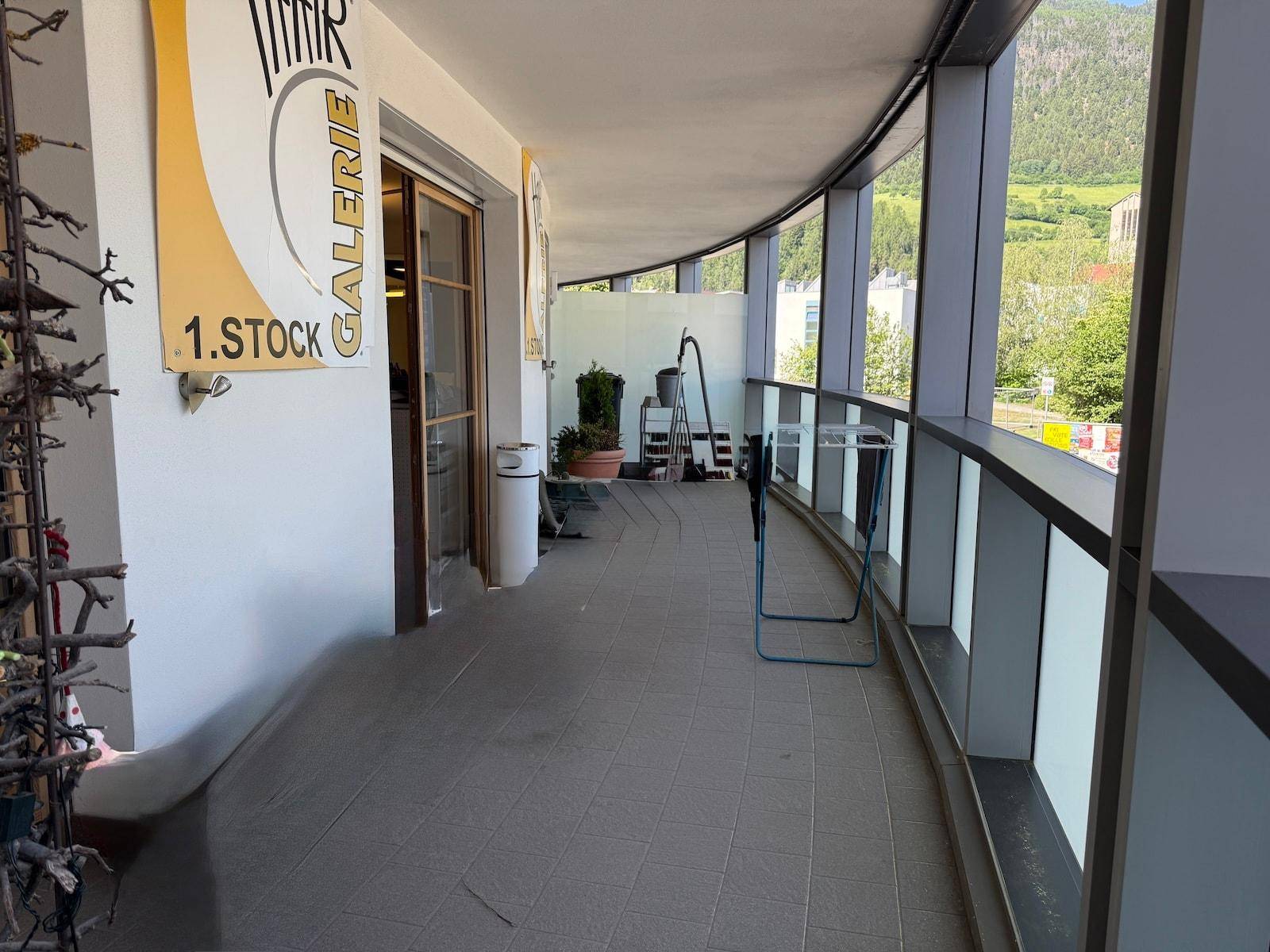 Langer, geschwungener Balkon mit Bergblick und Blick auf die umliegende Bebauung.