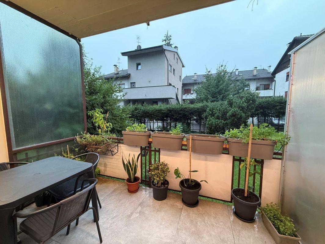 Möblierter Balkon mit Pflanzen und Blick auf die umliegenden Gebäude und Grünflächen.