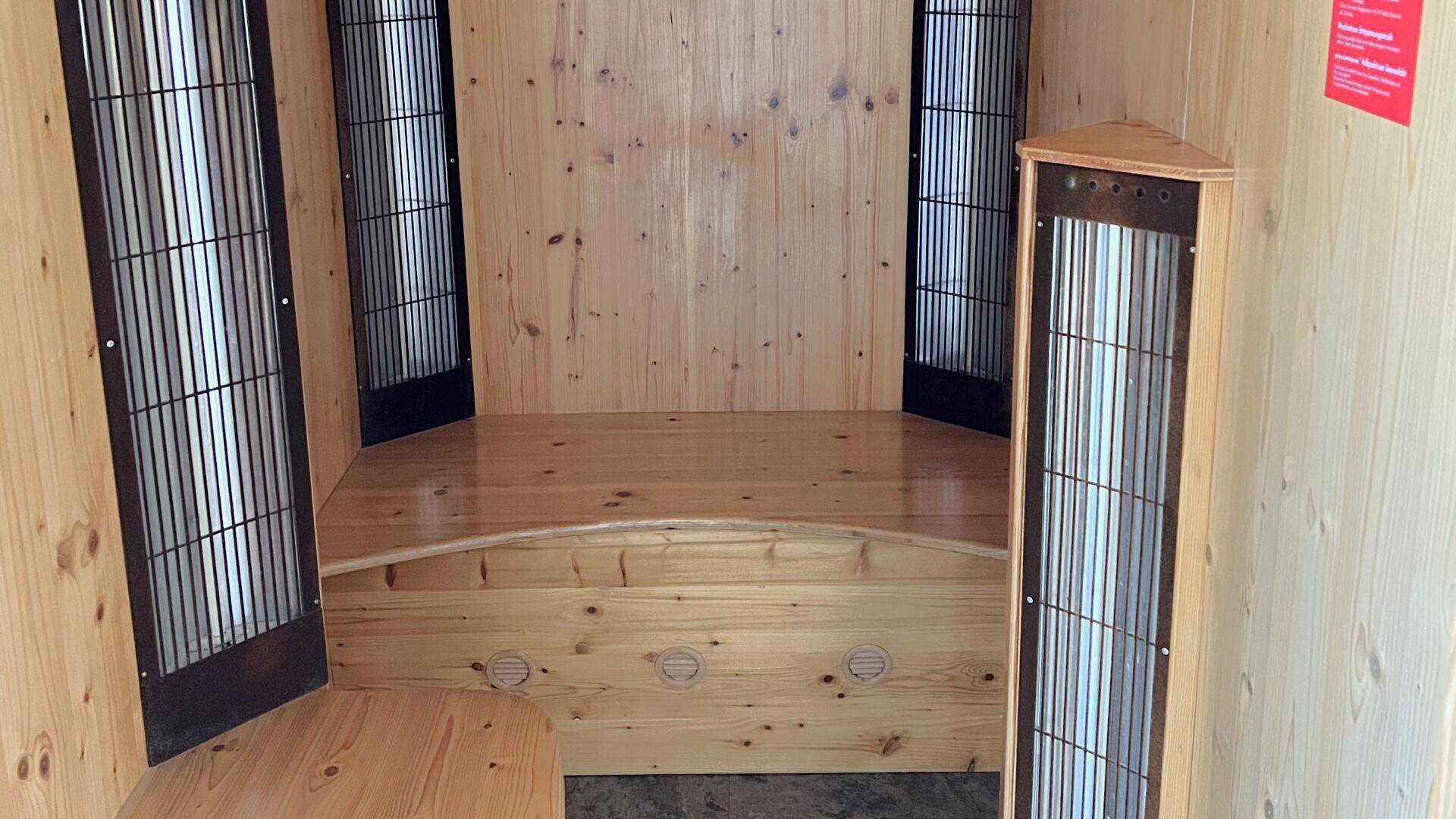 Gemütliche Infrarotkabine aus hellem Holz mit Sitzbank und vertikalen Heizelementen für Entspannung.