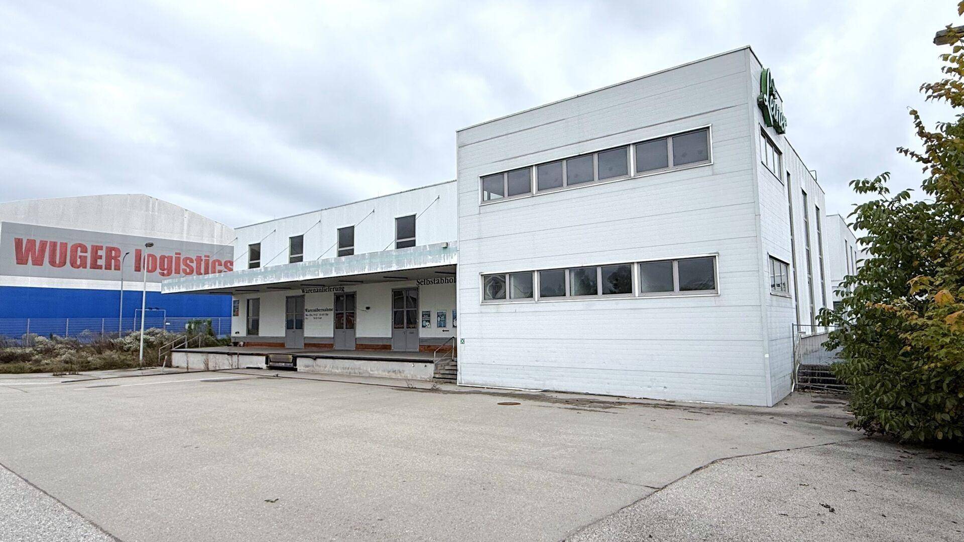 Seitenansicht des Gewerbegebäudes mit Laderampe und dem Schriftzug 'WUGER logistics' im Hintergrund.