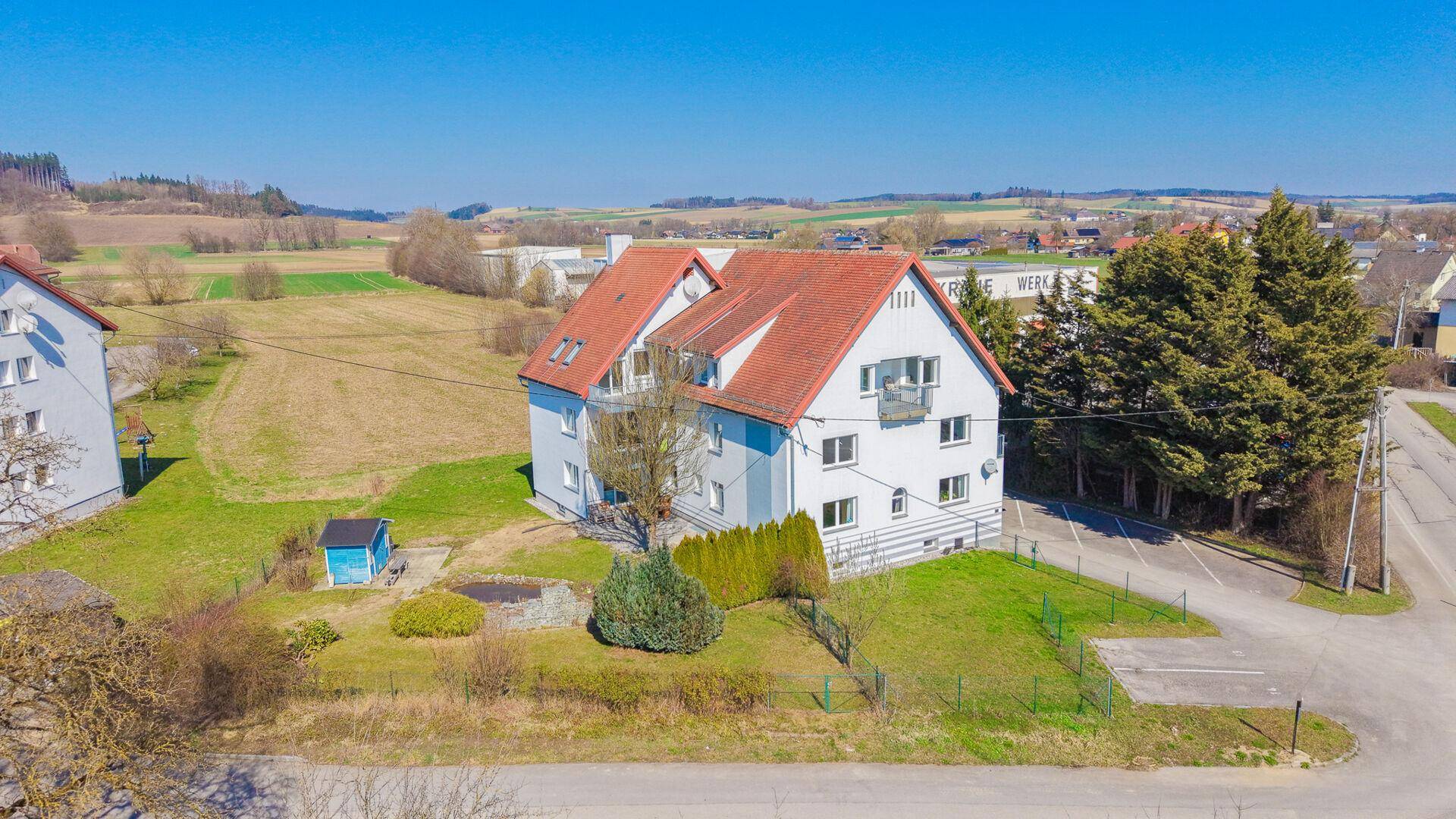 Weitläufige Luftaufnahme des Wohnhauses mit Garten und der umgebenden ländlichen Bebauung.