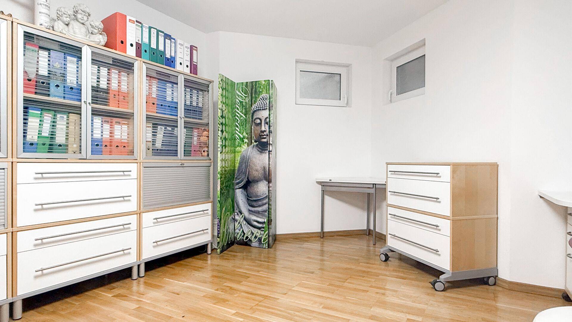Funktionales Büro mit Aktenschränken, Schreibtisch und Holzfußboden.