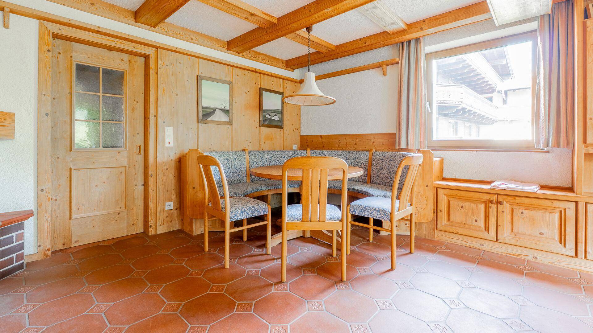 Essbereich im alpinen Stil mit Holztisch, Eckbank und Holzvertäfelung.