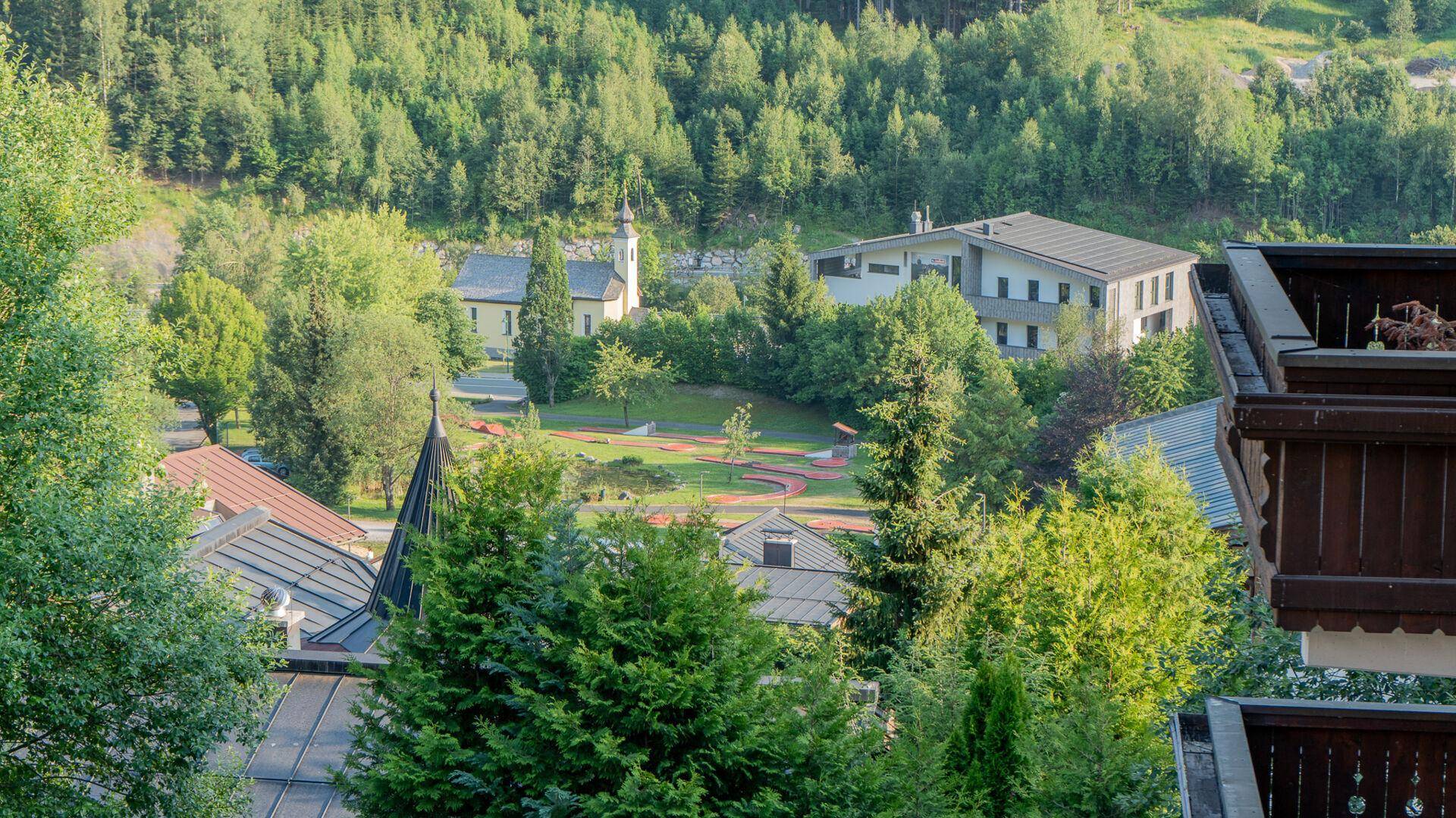Weitläufiger Blick auf die umliegende Landschaft mit Gebäuden, Bäumen und einem Park.