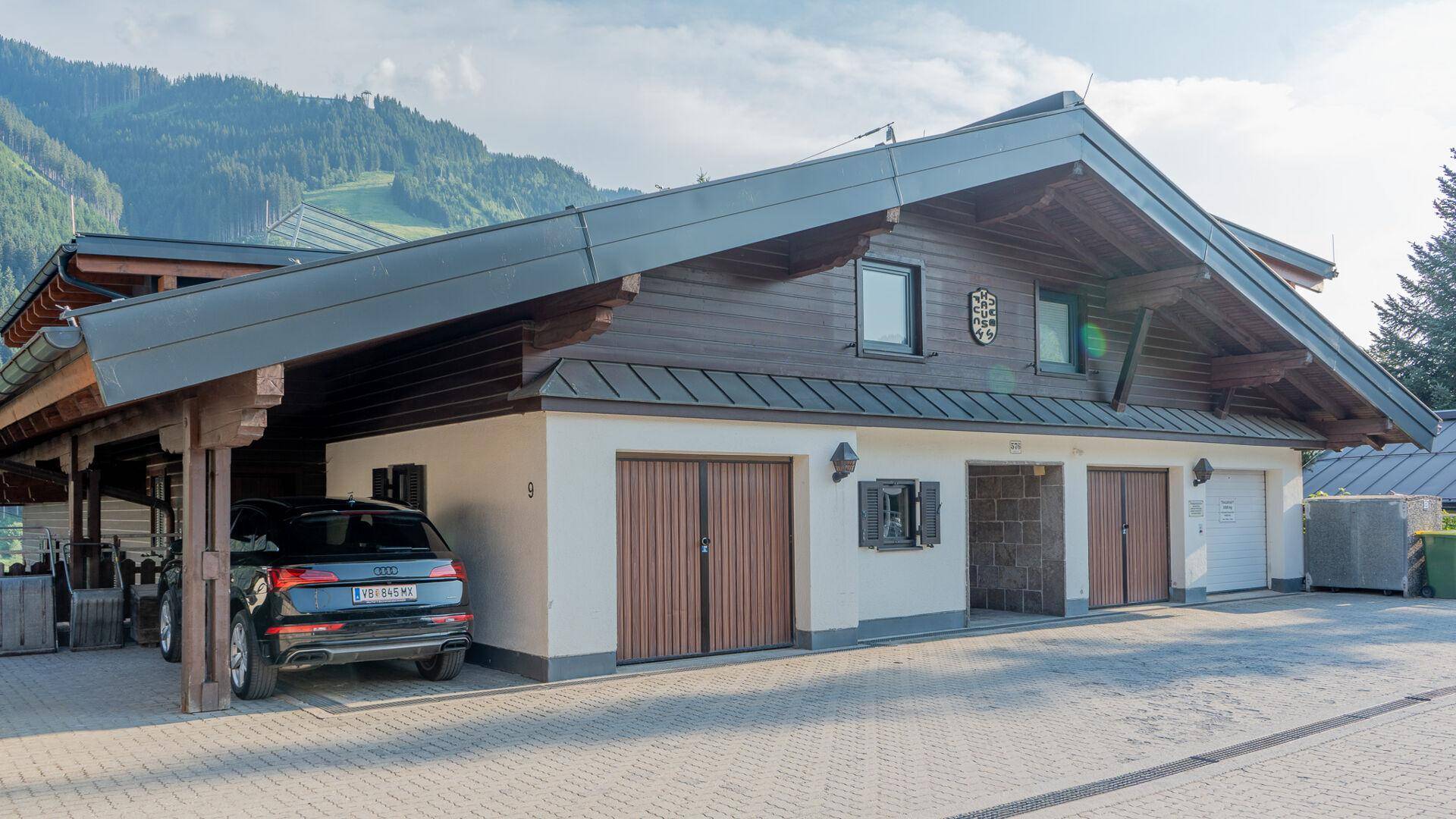 Traditionelles Gebäude mit Satteldach, Holzverkleidung und mehreren Garagentoren.