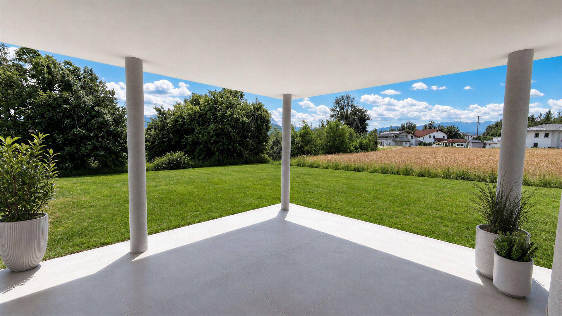 Überdachte Terrasse mit Säulen, Blick auf einen gepflegten Rasen, Felder und ferne Berge.